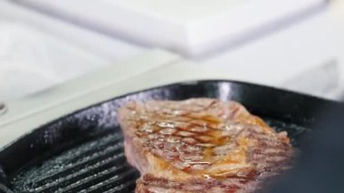 Mutfakta çalışıyorum. Şef tavada bir parça biftek kızartıyor. Üstüne meyve suyu ekliyorum.