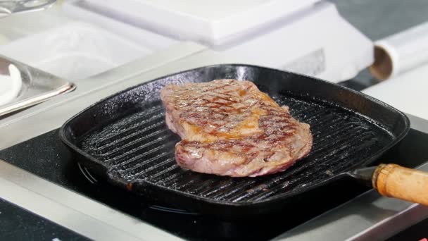 Trabajando en la cocina. Chef freír trozo de filete en la sartén — Vídeos de Stock