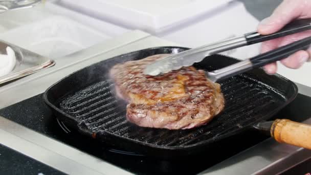 Restaurant kitchen. Chef frying piece of steak in the pan — Stock Video