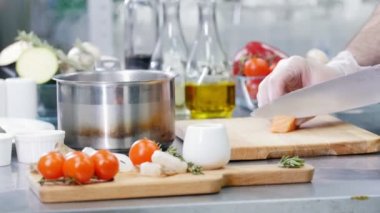 Mutfakta çalışan bir şef. Kırmızı balık kesmek