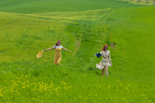 Deux femmes marchant sur une prairie vert vif — Photo