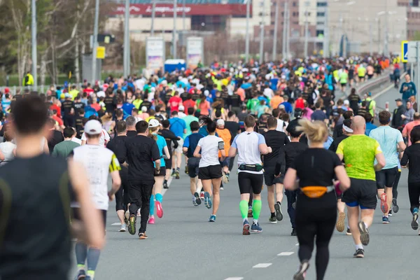 Marathon running in the city in daylight. View from the back