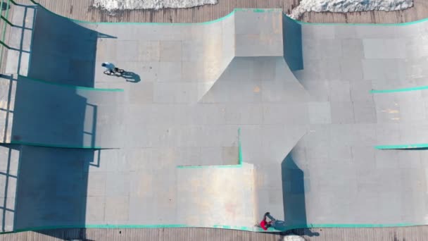 Vista aérea em um parque de skate. BMX piloto realizando truques nas rampas — Vídeo de Stock