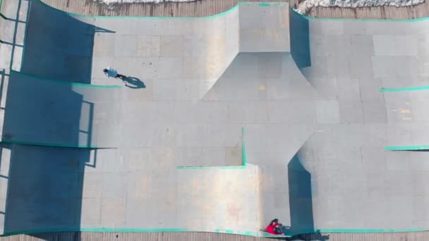 Vista aérea de un parque de skate. Jinete profesional de BMX realizando trucos en las rampas — Vídeo de stock