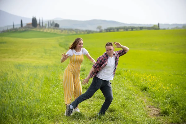 Молода смішна пара стоїть на зеленому лузі — стокове фото