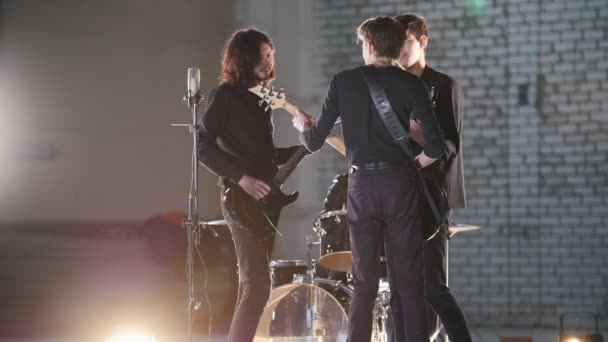 Una repetición. Un grupo joven de personas tocando música rock y discutiéndolo — Vídeos de Stock