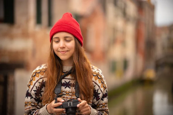 Egy csinos, fiatal nő áll az olasz utcán tartó kamerával. — Stock Fotó