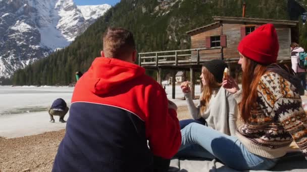 Jovens a viajar. Amigos fazendo um piquenique na costa e comendo sanduíches — Vídeo de Stock