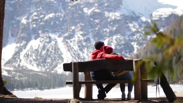 Jeune couple voyageant. Assis sur un banc et profitant de la vue — Video