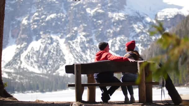Jeune couple voyageant. Assis sur un banc et parlant — Video