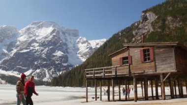 Lago di braies sahilinde el ele tutuşan genç bir çift