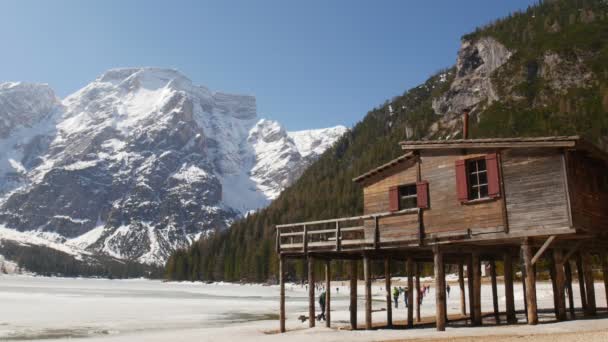 Les jeunes voyagent. Un peuple visitant lago di braies et marchant sur une côte — Video