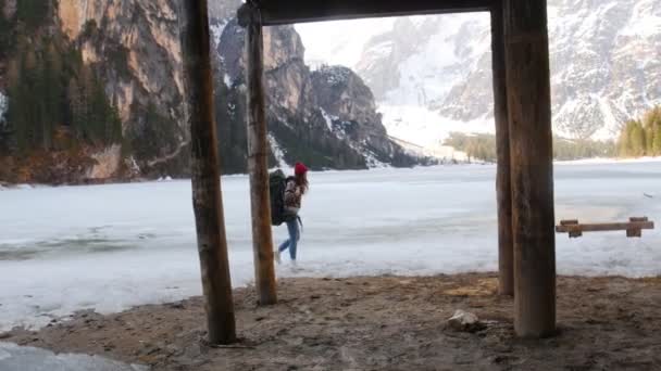 Młoda kobieta podróżująca po wybrzeżu lago di braies z dużym plecakiem — Wideo stockowe