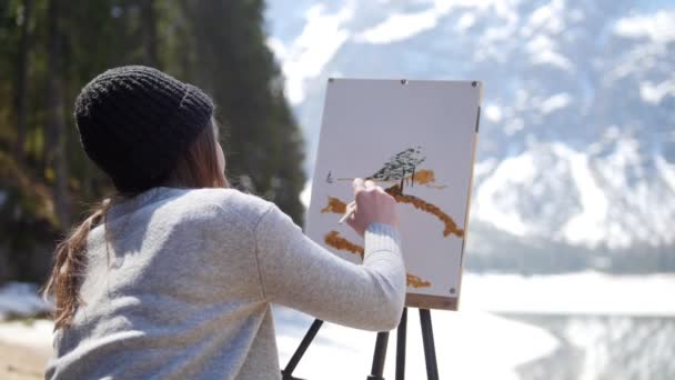 Dolomiten. eine junge Frau zeichnet auf einer Leinwand — Stockvideo