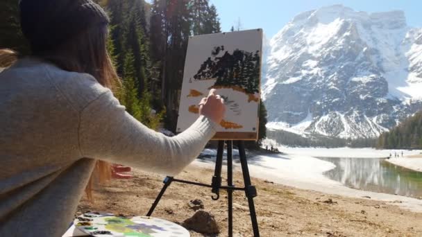 Dolomiten. eine junge Frau, die von Wald umgeben zeichnet. Wasser schöpfen — Stockvideo