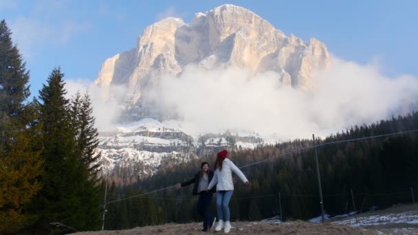 Deux jeunes femmes voyageant debout sur un fond de montagne et s'amusant — Video