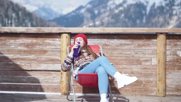 Una joven y bonita mujer tumbada en la tumbona y bebiendo agua de una botella — Vídeos de Stock