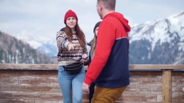 Duas jovens turista pedindo a um estranho para tirar uma foto delas. Em pé sobre um fundo de montanhas — Vídeo de Stock