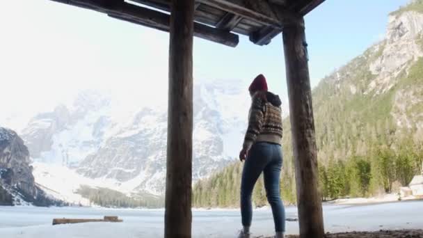 Joven mujer bonita caminando en un lago di braies costa bajo la cabaña — Vídeos de Stock