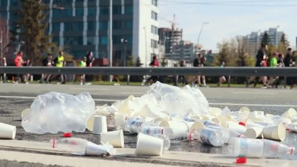 05-05-2019 RÚSSIA, KAZAN: Um monte de copos de plástico e garrafas vazias nas ruas enquanto uma maratona de corrida — Vídeo de Stock