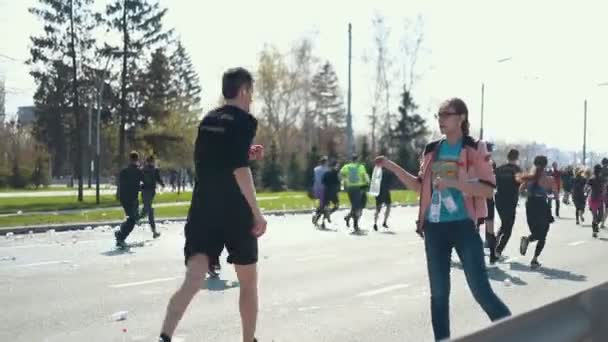 05-05-2019 RUSSIA, KAZAN: A running marathon in the city. A woman volunteer gives bottle of water to people — Stock Video
