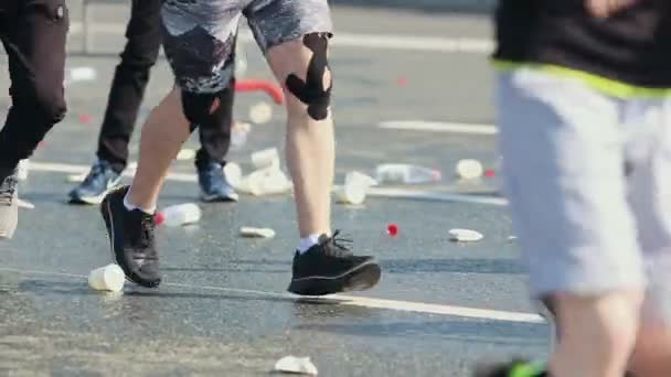 05-05-2019 RUSIA, KAZAN: Un maratón en marcha en la ciudad. Gente corriendo por la carretera cubierta de botellas vacías de agua — Vídeos de Stock