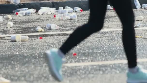 05-05-2019 RUSIA, KAZAN: Un maratón de carreras. Gente corriendo por la carretera cubierta de botellas vacías de agua — Vídeos de Stock