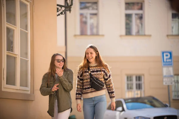 거리를 걷고 있는 두 명의 젊은 미소 짓는 여성 — 스톡 사진