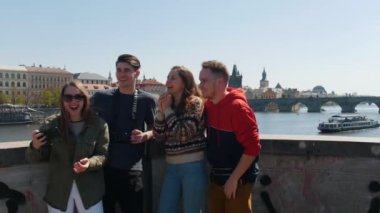 Köprüde durup selfie çeken genç bir arkadaş grubu.