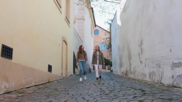 Dos mujeres jóvenes caminando por las estrechas calles — Vídeos de Stock