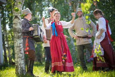 İki kadın insanların bir daire içinde dans - bunlardan biri akordeon ve şarkı çalar