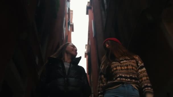 Duas mulheres jovens andando na rua estreita escura — Vídeo de Stock