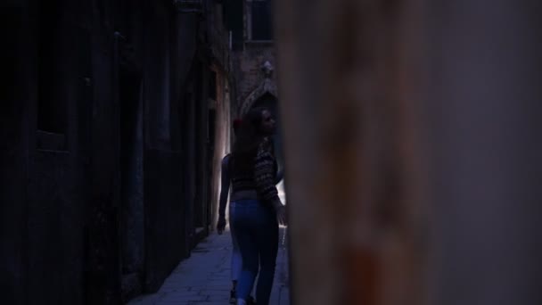 좁은 신비한 거리를 걷고있는 두 젊은 무서운 여성. 표시등이 꺼집니다.. — 비디오