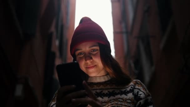 Женщина, стоящая на улице и смотрящая на экран телефона — стоковое видео