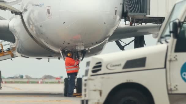 30 april 2019, Praag, Tsjechisch: Vaclav Havel Airport-een man werknemer onder het vliegtuig en het vliegtuig klaar te krijgen voor de vlucht — Stockvideo