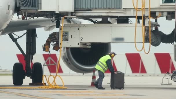 Um homem trabalhador transporta uma bagagem do avião — Vídeo de Stock