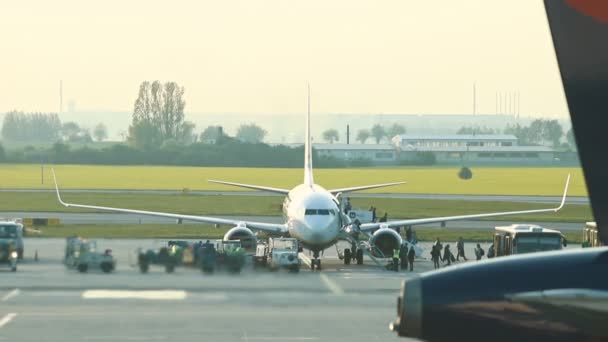 30 aprile 2019, PRAGUE, Cecoslovacchia: Aeroporto Vaclav Havel - Un calore proveniente dalla turbina riguarda l'aria e la distorce. Persone a piedi dall'aereo in autobus — Video Stock