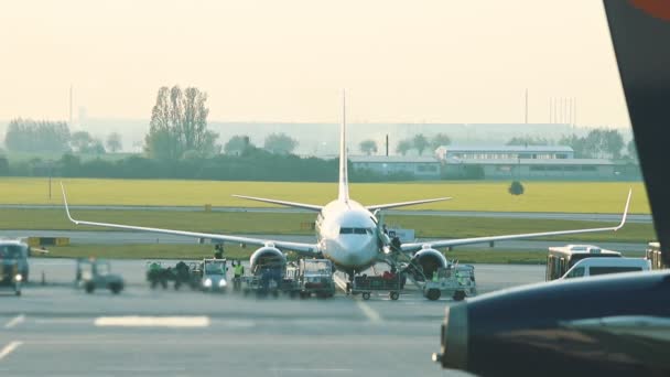 30 abril 2019, PRAGA, CHECA: Vaclav Havel aeropuerto - JOON AIRLINES - Un calor de la turbina se refiere al aire y lo distorsiona. Gente caminando desde el avión en el autobús — Vídeo de stock