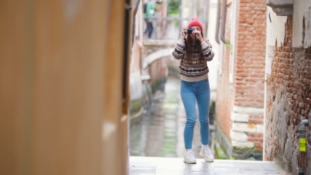 Una giovane donna in piedi per le strade di Venezia e scattare foto sulla sua macchina fotografica — Video Stock