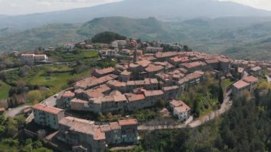 Ormanlarla çevrili eski kentin havadan görünümü. Turuncu çatılı tuğladan yapılmış bir sürü bina