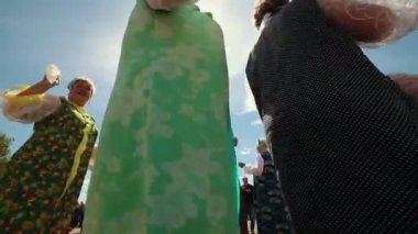 Rusya, Nikolskoe köyü, Tataristan Cumhuriyeti 25-05-2019: Bir köyde akordeon müziği yle tef ile şarkı söyleyen geleneksel kıyafetler giyen olgun bir kadın