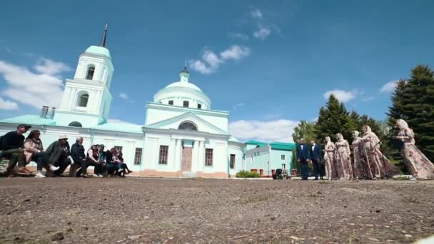 RUSIA, Nikolskoe village, República de Tartaristán 25-05-2019: Una mujer vestida con ropa tradicional rusa de pie frente a una iglesia y cantando canciones tradicionales — Vídeos de Stock