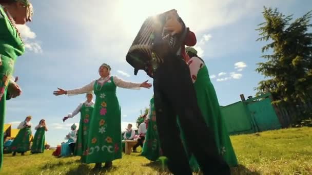 RUSSIA, Nikolskoe village, Republic of Tatarstan 25-05-2019: An old women in traditional clothes standing on the field and dancing by accordion music singing chastooshkas — Stock Video