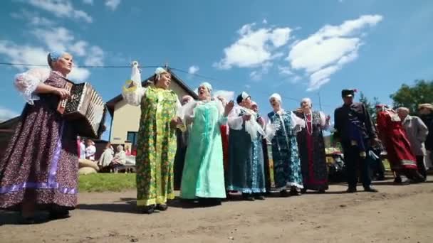 Oroszország, Nikolskoe falu, Köztársaság Tatarstan 25-05-2019: egy érett nő a hagyományos ruhák táncol és énekel a faluban harmonika zene — Stock videók