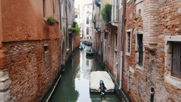 Un canal de agua en las calles estrechas de Venecia. Barcos amarrados — Vídeo de stock