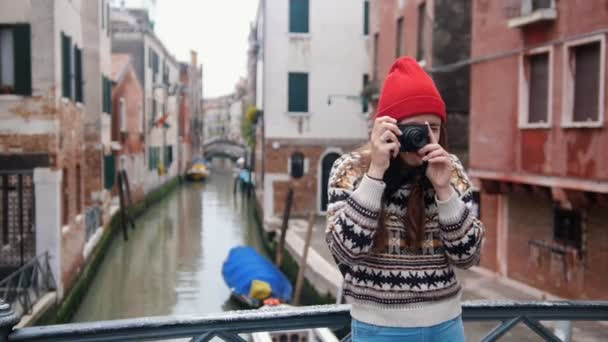 Jeune femme debout sur un fond de canal d'eau et prendre une photo — Video