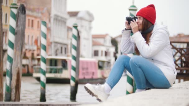 Jovem mulher sentada em blocos de concreto e tira fotos ao redor — Vídeo de Stock