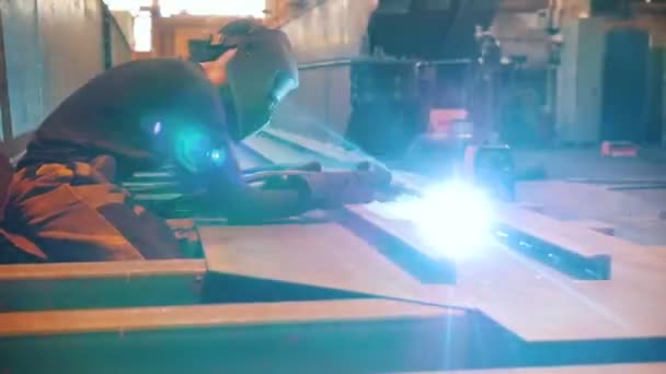 Construction plant. A man worker sitting at his workplace and using a welding machine. — Stock Video