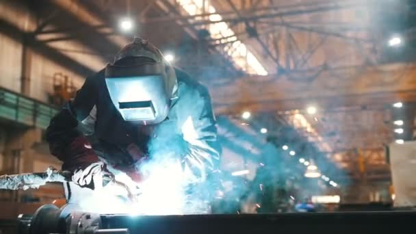 Construcción de plantas. Un hombre en un casco usando una máquina de soldadura para conectar detalles — Vídeos de Stock