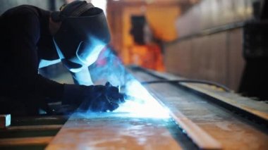 Bir adam kaynak makinesi ile çalışır. metal köşe kaynak